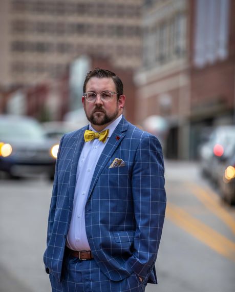 A picture of me in a suit standing next to a busy street.